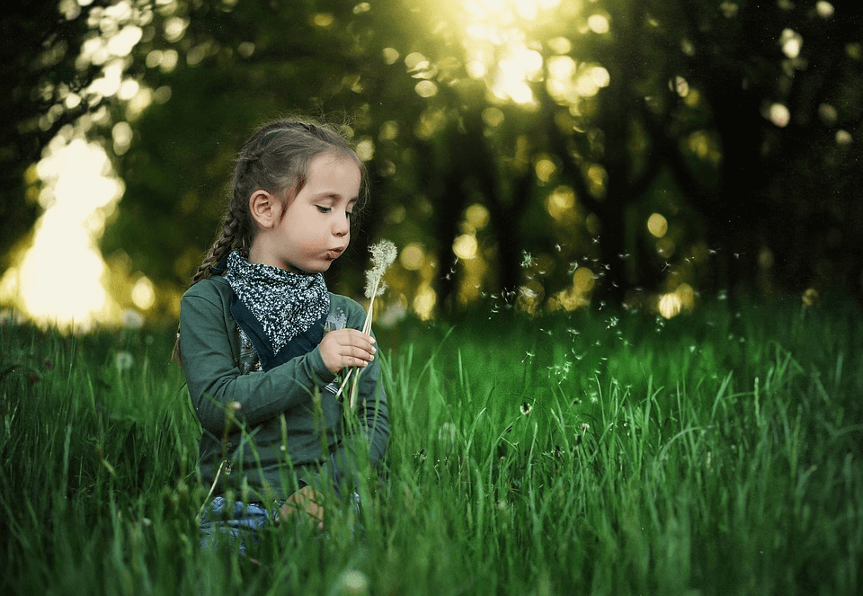 imagem de uma menina soprando uma flor para ilustrar como aproveitar a vitamina do sol no inverno