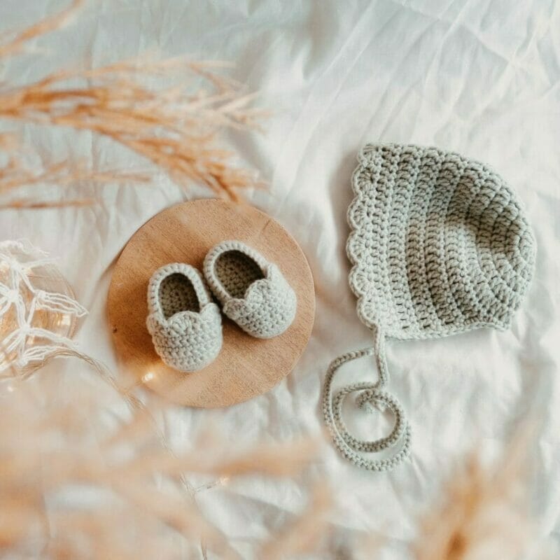 imagem de dois produtos para bebês: sapatinho e touca de crochê